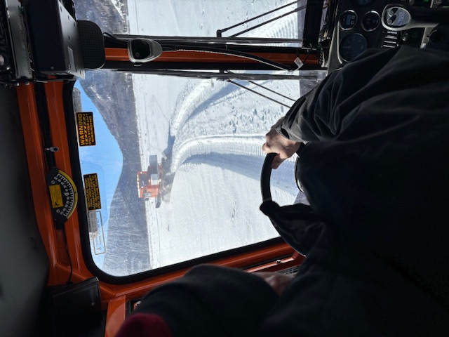 Public safety technician driving a snowcat through snow.